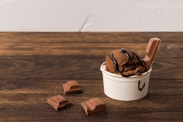 Taza de helado en mesa de madera